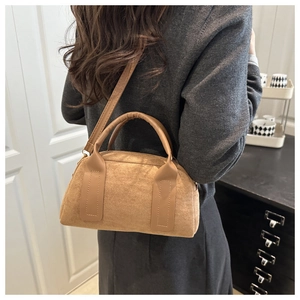 Detail der braunen Wildledertasche mit verstellbarem Gurt und Textur am Modell