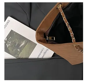 Détails de la fermeture éclair métallique et de la bandoulière chaîne dorée du sac cabas