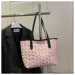 Détail du cabas plissé rose avec motifs nœuds noirs et fines anses en cuir