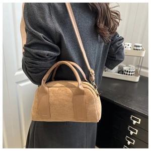 Braune Wildleder-Handtasche als Umhängetasche und Henkeltasche am Modell im modernen Raum