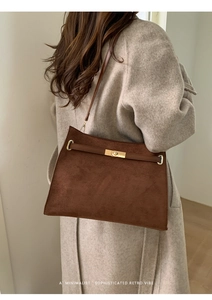 Détail du sac cabas en daim marron foncé avec fermoir doré et fine bandoulière en cuir