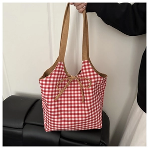 Detail of red and white checkered tote bag with brown straps and bow tie decoration