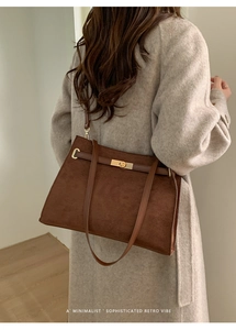 Détail d'un sac cabas rétro en daim marron foncé avec un fermoir rotatif doré élégant