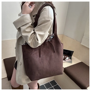 Detail of suede tote bag showing brown matte texture and black white plaid lining