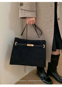 Sac fourre-tout noir en daim avec boucle dorée porté par un mannequin de mode