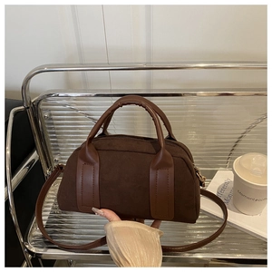 Nahaufnahme der braunen Wildleder-Boston-Bag mit Glattlederbesatz im Regal