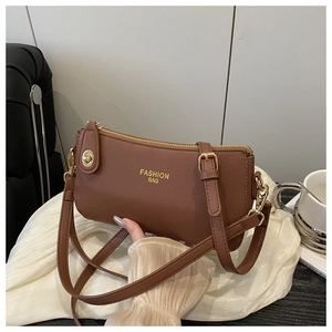 Close-up of brown litchi pattern leather bag with golden hardware and fashion lettering