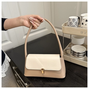 Détail du sac à bandoulière beige avec boucle dorée et texture en cuir synthétique