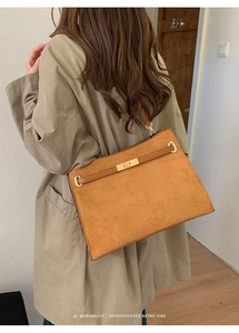 Gros plan du sac cabas en daim marron avec boucle dorée et design rétro minimaliste