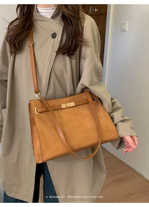 Détail du sac cabas en daim marron avec fermoir tournant doré et sangles de style rétro