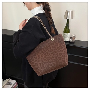 Gros plan du sac cabas léopard marron en daim avec une bandoulière chaîne dorée
