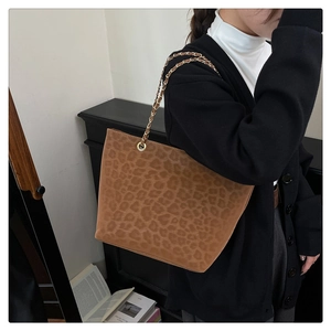 Détail du sac cabas léopard doux avec une élégante chaîne dorée et une bandoulière en cuir