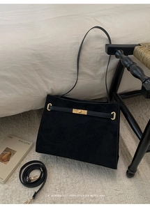 Détail du sac cabas en suédine noire avec fermoir rotatif doré et bandoulière réglable