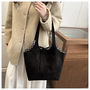 Detail of black tote bag with bow tie showing spacious interior and checkered lining