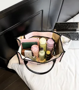 Detailed interior of a pink jacquard tote bag filled with a tablet, umbrella, and essentials