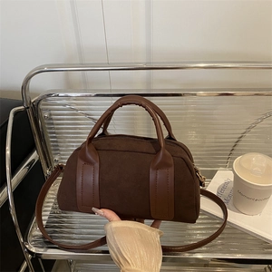 Retro dunkelbraune Wildleder Handtasche auf Display mit schickem Leder Tragegriff