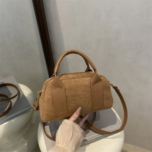 Retro braune Wildleder-Handtasche mit Ledergriffen auf weißem Hocker, Mode 2025
