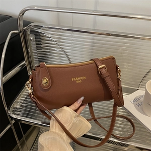 Brown lychee texture crossbody pillow bag with gold zipper and metal lock closure