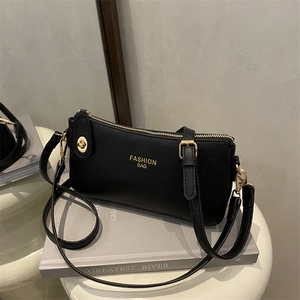 Elegant black lychee grain crossbody pillow bag with gold hardware and fashion lettering