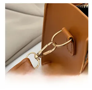 Macro shot of durable golden metal hardware and premium stitching on a brown leather bag