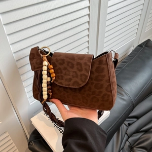 Crossbody leopard print bag with suede texture, woven strap and wooden bead charm
