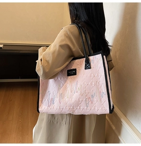 Détail du sac cabas rose matelassé avec broderies ondulées et anses en cuir noir
