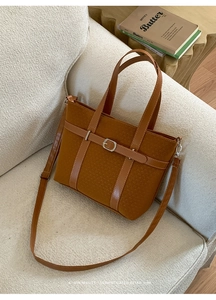 Détail du sac cabas rétro en tweed caramel avec anses en cuir sur un canapé
