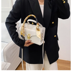 White faux leather crossbody bag detail with gold oval clasp and silk scarf handle wrap
