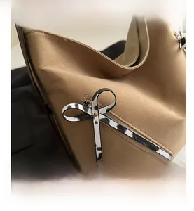 Detail of khaki suede tote bag featuring a leopard print bow and bronze metal buckle
