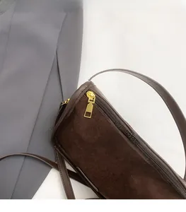 Detail of dark brown suede tote bag featuring high-quality golden metal zipper hardware