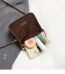 Macro shot of large capacity dark brown suede tote interior with cosmetics and zip detail