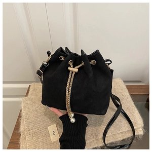 Detail of black drawstring bucket bag with gold chain and white pearl charms on scarf
