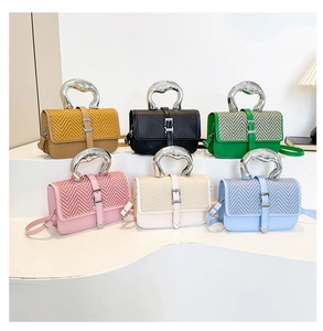 Detailed view of fashion shoulder bags with woven texture and unique silver metal handles
