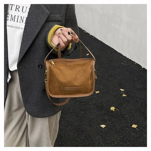 Detailed view of brown suede tote bag with gold hardware and stylish shoulder strap