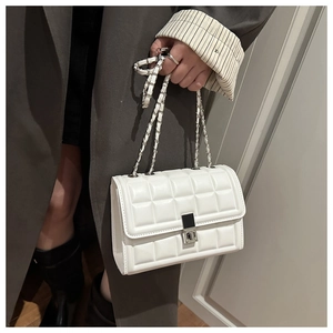 Close-up of white quilted crossbody bag with silver square buckle and chain strap