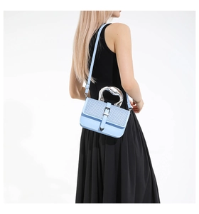 Light blue crossbody bag featuring chevron textured flap and silver liquid metal handle