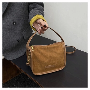 Detail of dark brown matte suede texture and elegant gold zipper on a large tote bag