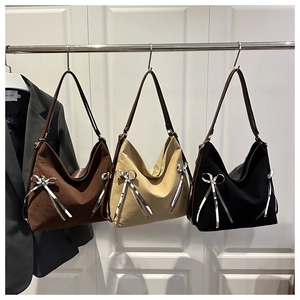 Three canvas tote bags in brown, beige and black colors hanging on a display rod