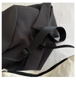 Detail of adjustable black nylon strap and plastic buckle on beige waterproof fabric bag