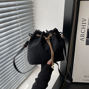 Retro matte black bucket bag with gold chain drawstring and elegant pearl accents