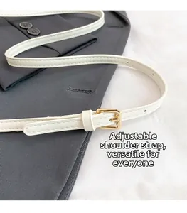 Close-up of white leather adjustable strap with gold buckle and fine stitching details