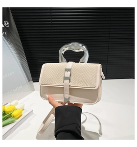 Detail of minimalist beige PU leather crossbody bag with silver liquid metal handle