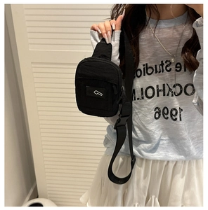 Détail d'un sac de poitrine minimaliste en nylon noir avec sangle réglable et zip
