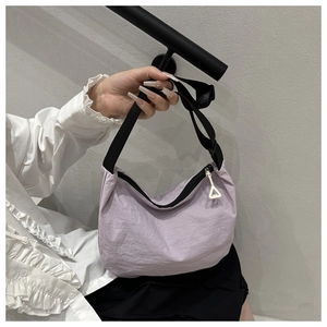 Detailed shot of lavender nylon dumpling bag with black zipper and adjustable shoulder strap