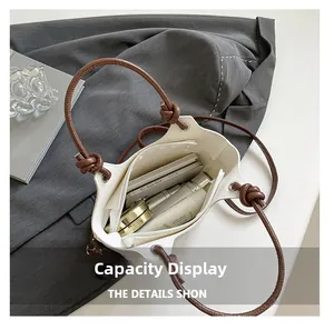 Spacious interior of beige leather bucket bag showing phone and cosmetics storage