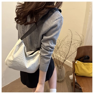 Detail of minimalist waterproof nylon crossbody bags in white and yellow colors