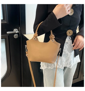 Detail of light brown bucket bag featuring a knotted handle and adjustable strap