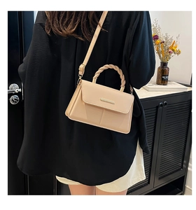 Détail du sac bandoulière abricot avec poignée tressée et bandoulière réglable