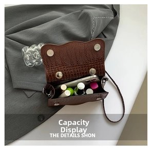 Detail of brown crocodile pattern handbag interior capacity with magnetic snap closure