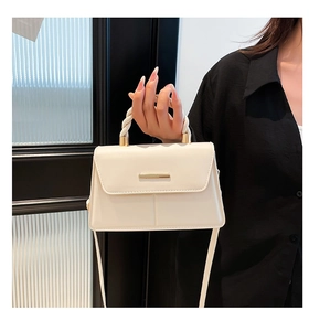 Détail du sac à bandoulière blanc cassé avec poignée tressée et garniture dorée